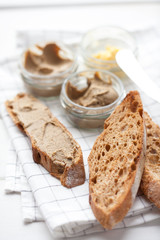 Bread with veal and rabbit pate with butter on a textile background.