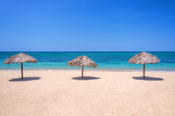 Fototapeta na wymiar Straw umbrellas on a beautiful tropical beach
