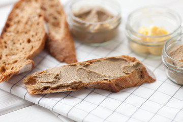Bread with veal and rabbit pate with butter on a textile background. Top view