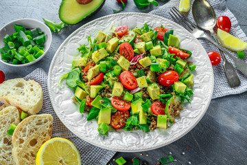 Quinoa tabbouleh salad with avocado, tomatoes, cucumber, green onion. Concept healthy food.