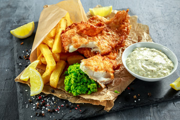 British Traditional Fish and chips with mashed peas, tartar sauce on crumpled paper. - obrazy, fototapety, plakaty