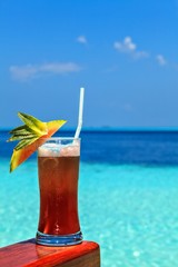 Glass of drink is on a beach table