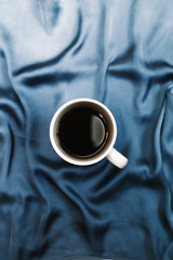 Composition with blue cloth and a coffee cup. Flat lay, top view. Morning concept