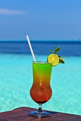 Glass of drink is on a beach table