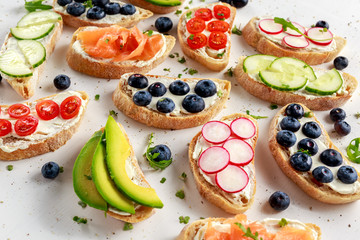 Homemade summer toast with cream cheese Smoked Salmon, Blueberries, Radish, Cucumber, Avocado and cress salad. Fresh healthy concept food.