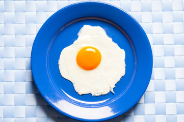 egg omelette on a blue plate and light blue background from the top view 