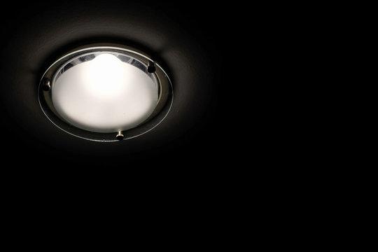 Lamp on ceiling in black background.