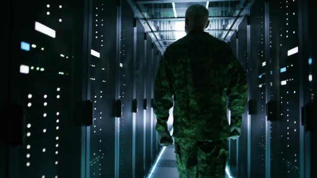 Soldier Walks into Data Center Through Sliding Doors and Walks along Rows of Working Rack Servers.  Shot on RED EPIC-W 8K Helium Cinema Camera.