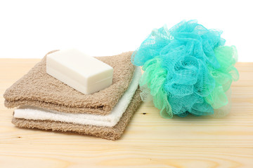 soap with bath towel and wisp of bast on wood background