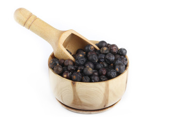 juniper berries in wooden cup isolated