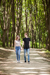 Fototapeta na wymiar Couple taking a walk in the forest. Lifestyle and relationship. Young inlove boyfriend and girlfriend
