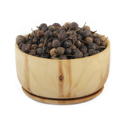 cubeba peppercorn in wooden cup isolated