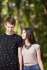 Obraz premium Young couple taking a walk in the park. Lifestyle and relationship. Young inlove boyfriend and girlfriend