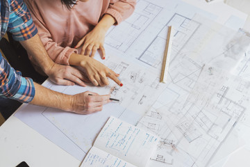 Hands of designers working with blueprint