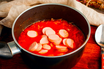 Tomato soup with sausages and cabbage, the process of cooking
