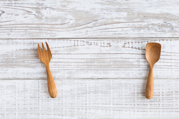 Wooden spoon and fork on white wooden table from top view,use for background food concept