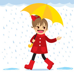Cute little girl in red coat and boots with big yellow umbrella walking under gentle rain