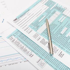 Obraz premium US 1040 Tax Form and silver ball pen over it - close up studio shot