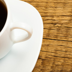 Close up studio shot of a cup of coffee on old wooden table
