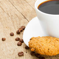 White cup of plain black coffee with cookies next to it