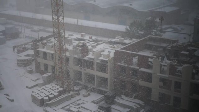 At the construction site of the house from the crisp is snowing, slow movement. Slow motion. HD. 1920x1080.