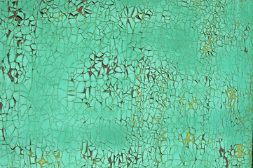 Old cracked paint pattern on rusty background. Peeling green grunge material. Damaged metal surface. Scratched plate