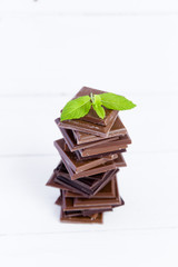 Stack of chocolate slices with mint leaf on a wooden table