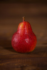 Pear red color on wooden background.