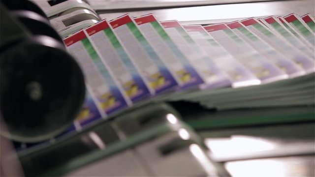 print plant factory, magazine transports on conveyor belt line after printing units and folder pan on print press typography machine in work