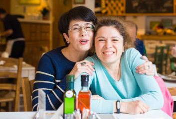 Love of mother and daughter. Happy women in a nice cafe with copy space on blurred background. Aged woman and her adult daughter at cafe. Mothers day.