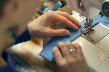 Seamstress. A woman works on a sewing machine. Work at home.