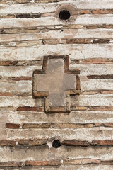 Cross on the wall of an ancient masonry. Backgrounds