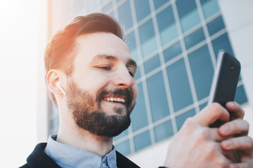 Happy businessman with wireless headphones listening to music on outdoors