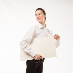 Young happy woman showing presentation, pointing on placard over gray background