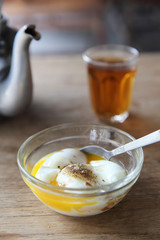Local Thai morning food hot tea, soft boiled eggs on wood background