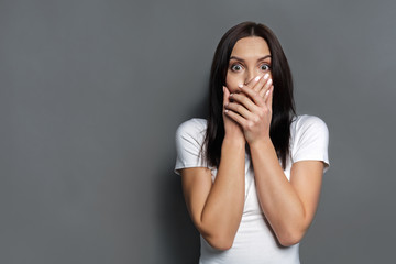 Scared woman covering mouth with hands