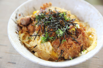 Japanese deep fried pork with egg on rice , Katsudon on wood background
