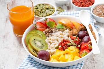 oatmeal porridge with fresh fruit and superfoods for healthy breakfast