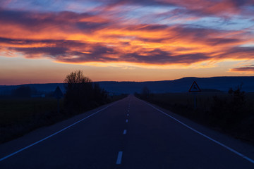 Recta en carretera  y horizonte con bonito cielo de atardecer al anochecer