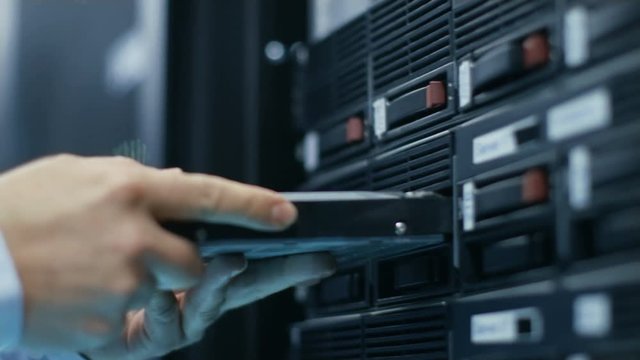 In Fully Working Data Center IT Engineer Installs Hard Drive into Server Rack. Detailed and Tehnically Accurate Footage. Shot on RED EPIC-W 8K Helium Cinema Camera.