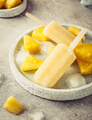Retro style toned photo of homemade frozen pineapple juice popsicles. Summer food concept.