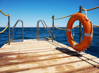 Wooden pier near the sea with lifebuoy