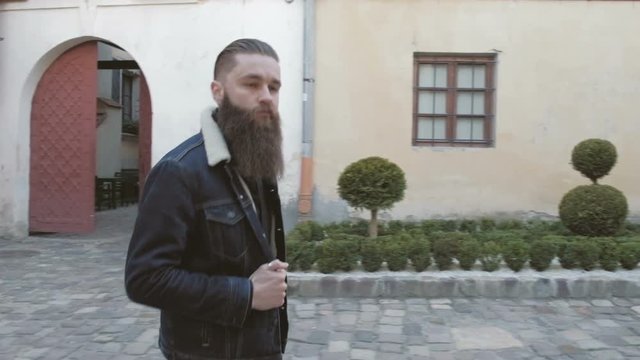 Handsome bearded man posing in the street, ,brutal hipster portrait