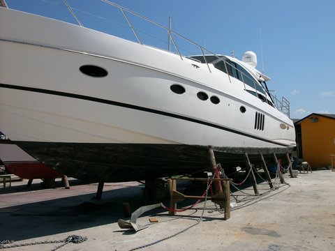 Strahlend wei&szlig;e Luxusyacht im Trockendock im Sommer vor blauem Himmel im Sonnenschein im Yachthafen von Alacati bei Cesme am &Auml;g&auml;ischen Meer in der Provinz Izmir in der T&uuml;rkei