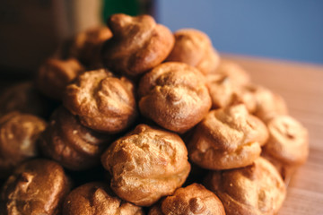 Traditional French dessert profiteroles pastry or eclair on plate. Desserts for party with space for text.