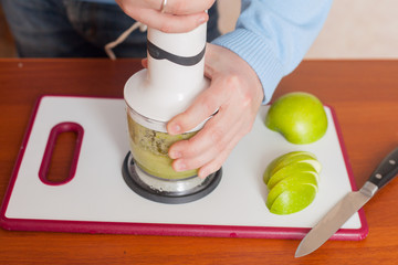 man prepares in a blender dessert, smoothies, apples
