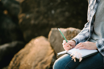 woman writing on a journal about her hiking trip,flare light
