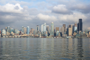 Fototapeta premium SEATTLE, WASHINGTON, USA - JAN 25th, 2017: A view on Seattle downtown from the waters of Puget Sound. Piers, skyscrapers, Space Needle and Ferris wheel in Seattle city before sunset