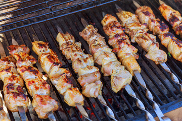 Grilled kebab cooking on metal skewer closeup. Roasted meat cooked at barbecue.