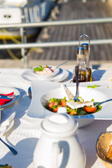 Greek salad or Fresh tasty vegetable salad with white feta cheese on the table in Restaurant on a beach.